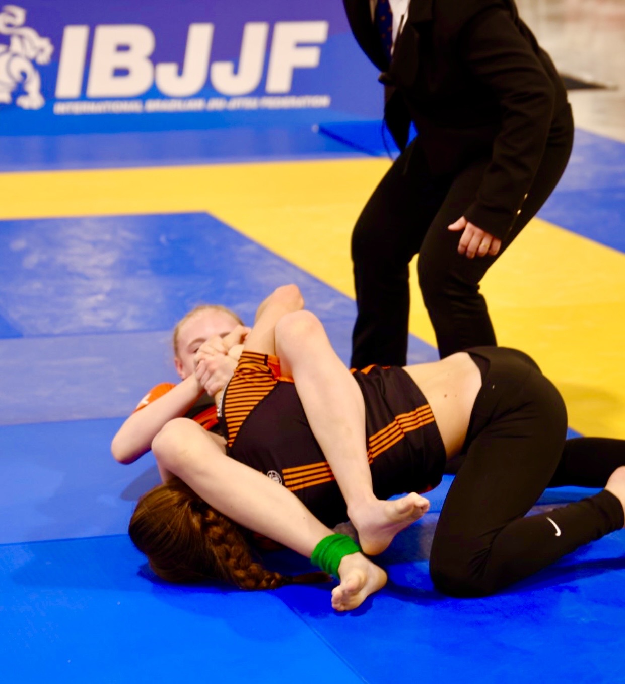 Additional competition image from the 2024 IBJJF Pan Kids No-Gi Championship bracket. The subject is shown in a control-to-submission transition position. IBJJF branding visible on the competition mat backdrop.